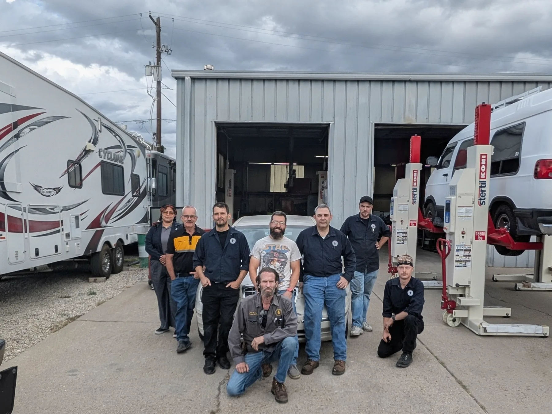 Current Wizard's Automotive and RV team outside the Bountiful shop with an RV and service vehicles, including veteran Nate Demer