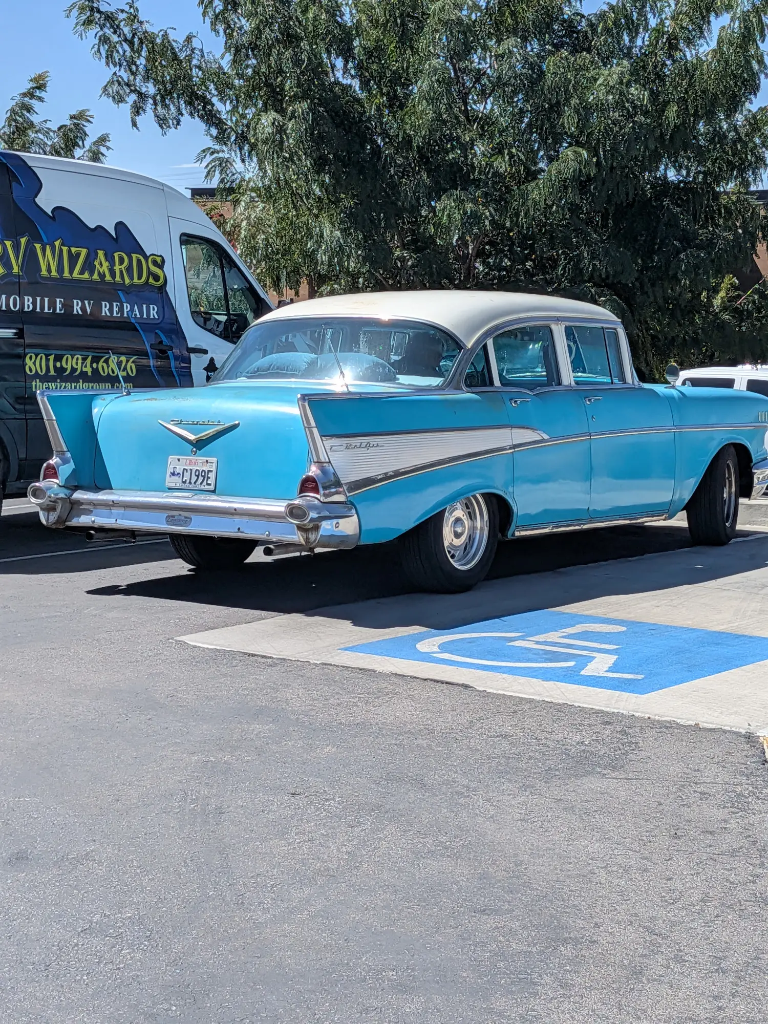 Classic Chevrolet parked beside the branded RV Wizards mobile repair van