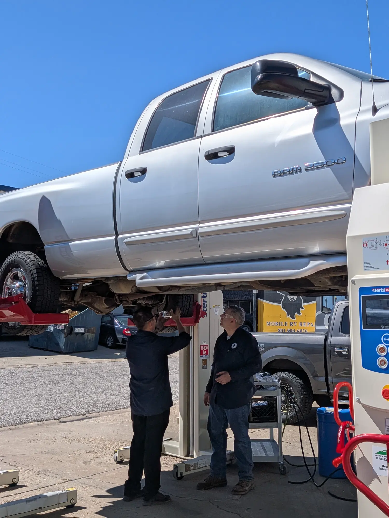 Wizard's team inspecting a RAM 2500 diesel truck raised on a mobile lift