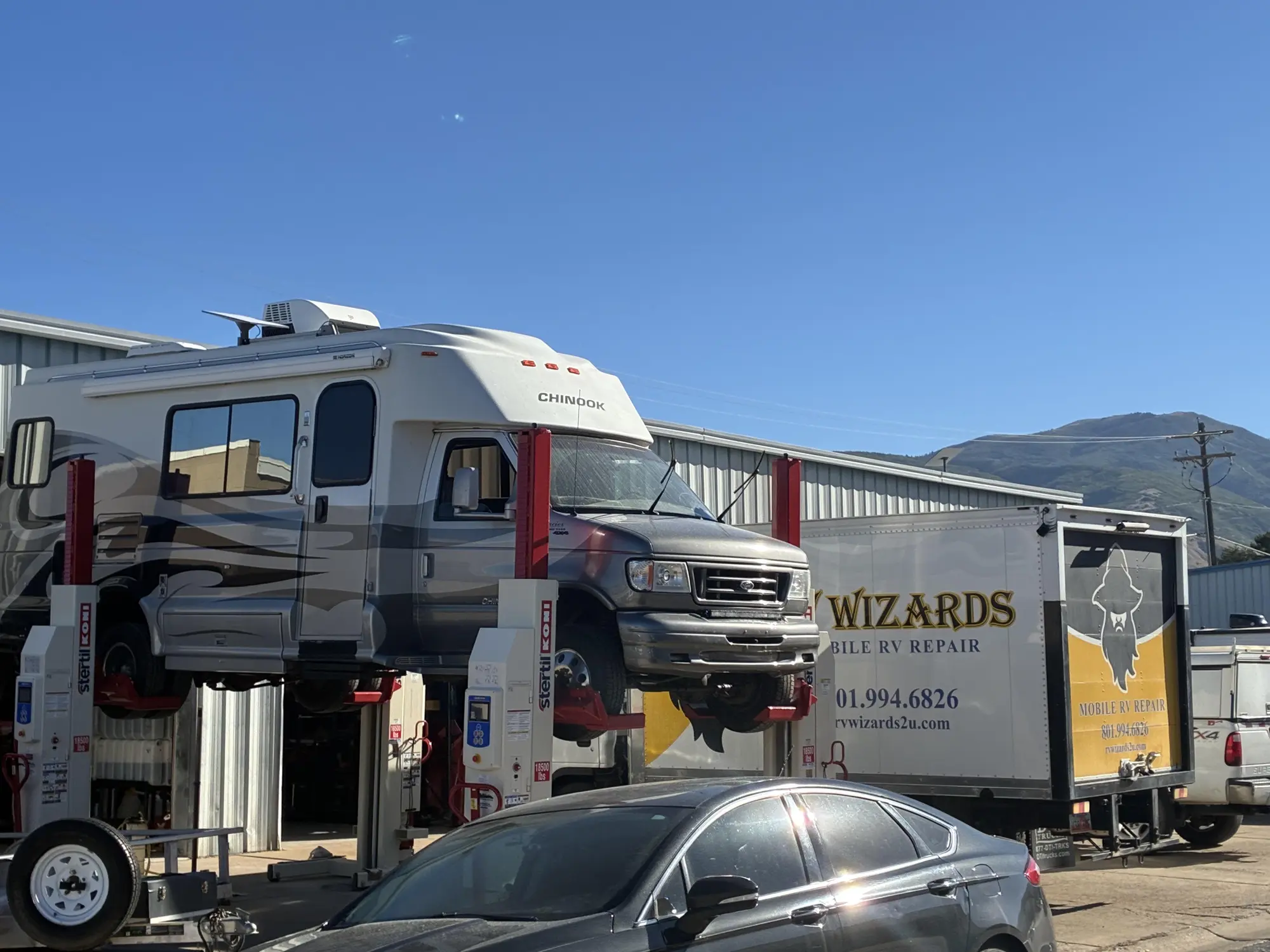 Chinook motorhome raised on a mobile vehicle lift at the Wizard's shop