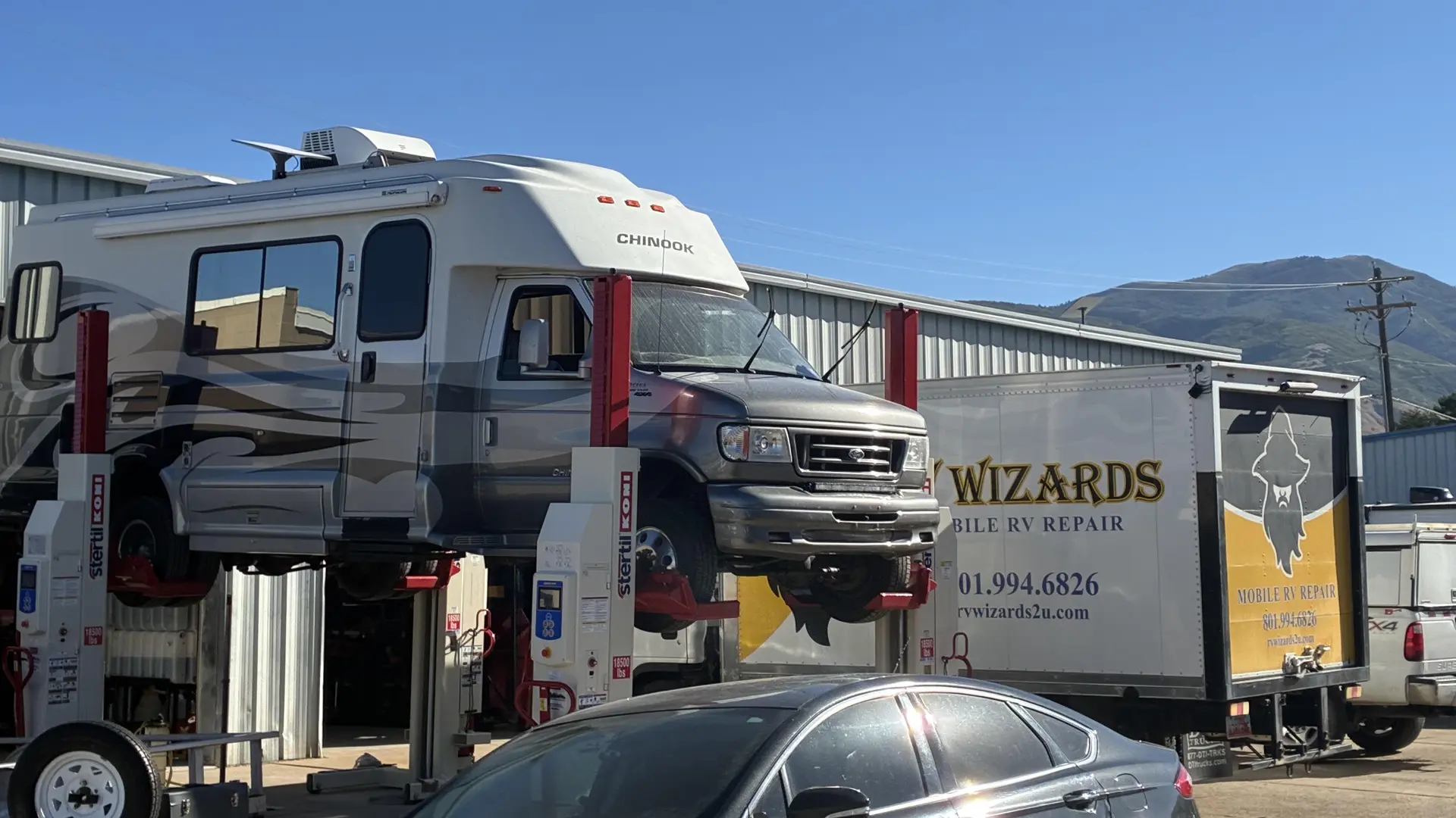 Chinook motorhome raised on a service lift outside the Wizard's Automotive and RV shop in Utah